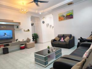 een woonkamer met banken en een flatscreen-tv bij Taiping Vacation Home in Taiping