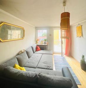 a living room with a gray couch and a mirror at Helle, grosse, zentrale Wohnung mit Balkon in Munich