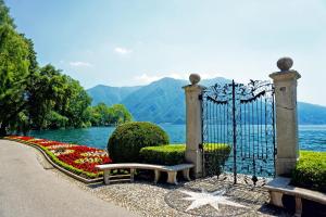 a gate with a bench in front of a lake at Pool House - Happy Rentals in Lugano +12 photos