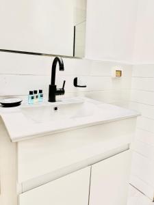 a white bathroom with a sink and a mirror at Underground in Tel Aviv