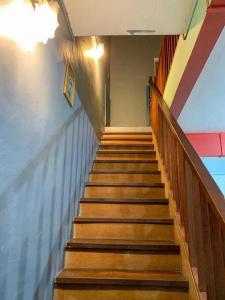 uma escada num edifício com escadas de madeira em GayaMas Homestay em Sandakan