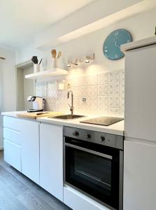 uma cozinha branca com um lavatório e um frigorífico em Ferienhaus Anni em Kreuth