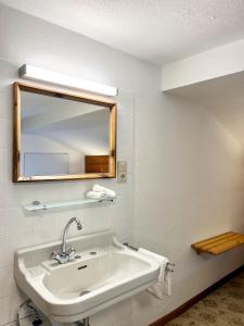 a white bathroom with a sink and a mirror at Ferienhaus Anni in Kreuth