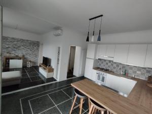 una cucina con mobili bianchi e un tavolo di legno di Brezza di Mare a Lavagna