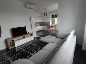 un soggiorno con un divano e una TV di Brezza di Mare a Lavagna