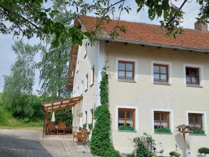 Cette grande maison blanche dispose d'une terrasse couverte. dans l'établissement Gschwandnerhof, à Michelsneukirchen