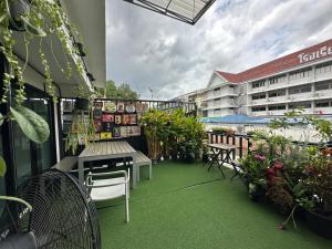 Jam Hostel Bangkok في بانكوك: بلكونه فيها طاوله وكراسي ومبنى