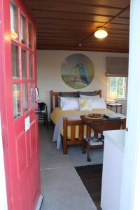 a bedroom with a bed and a red door at The Studio - Huntly House in Auckland