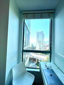 a desk and a chair in a room with a window at Stunning ocean (sound of waves) in Vancouver