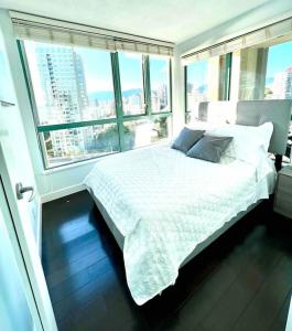 um quarto com uma cama num quarto com janelas em Stunning ocean (sound of waves) em Vancouver