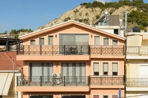 a building with balconies and a mountain in the background at Zissis Suites Downtown Apartment in Zakynthos Town