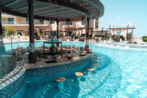 - une piscine d'eau bleue dans un complexe dans l'établissement Hilton Doha The Pearl, à Doha