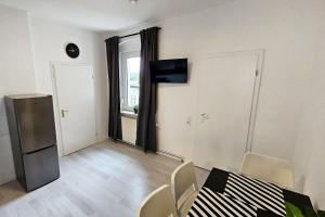 comedor con mesa, sillas y nevera en Apartments in Nienburg (Saale), en Grimschleben