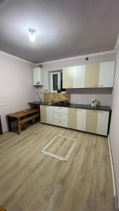a large kitchen with white cabinets and a wooden floor at Sevan cottage in Sevan