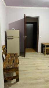 um quarto com um frigorífico e um banco de madeira em Sevan cottage em Sevan