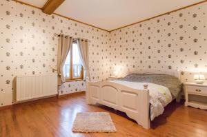 1 dormitorio con cama blanca y ventana en Le moulin de la lhuitrelle, 