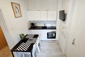 una pequeña cocina con armarios blancos, mesa y sillas en Apartments in Nienburg (Saale), en Grimschleben