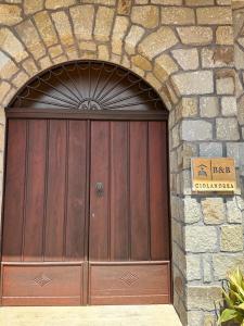 uma grande porta de madeira numa parede de pedra em B&B Ciolandrea em San Giovanni a Piro