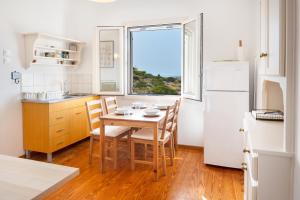 a kitchen with a table and chairs and a window at Gaia Seaview Residence Irakleia in Áyios Yeóryios