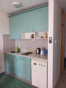 a kitchen with blue cabinets and a stove top oven at Apartment Budva in Budva