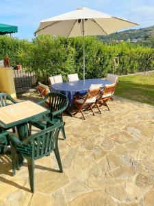 un tavolo e sedie con ombrellone su un patio di Casa Colleverde a Matonti