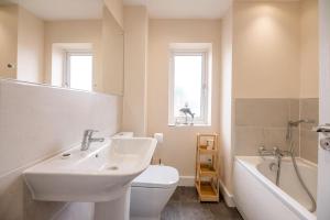 een badkamer met een wastafel, een toilet en een bad bij Spindrift, Felixstowe in Felixstowe +53 foto's