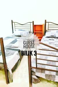 twee bedden met een bord dat leest laagste pension blitz drie bij Loveyna guest house in Kuantan