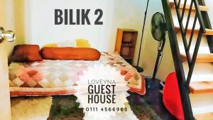 een slaapkamer met een bed en een pension bij Loveyna guest house in Kuantan