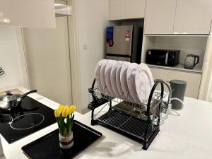 a dish drying rack on a kitchen counter with yellow flowers at Teega 12pax Cozy 4BR w Bathtub by Our Stay in Nusajaya
