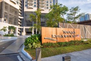 a sign in front of a tall building at Teega 12pax Cozy 4BR w Bathtub by Our Stay in Nusajaya