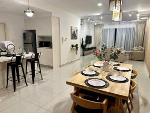 uma sala de jantar e cozinha com mesa e cadeiras em Teega 12pax Cozy 4BR w Bathtub by Our Stay em Nusajaya