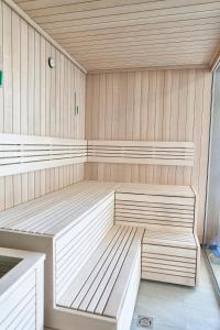 una sauna con 2 bancos en una sala de madera en SZAFIROWE APARTAMENTY 3 kryty basen i sauna RESORT KLIFOWA en Rewal