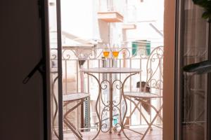 a balcony with a table with two glasses of wine at ALMAMI Loft & Rooms in Monopoli