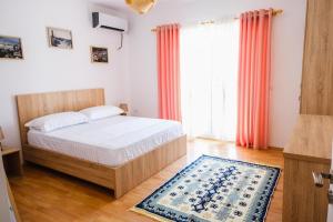 ein Schlafzimmer mit einem Bett und einem großen Fenster in der Unterkunft Matias sweetest home in Tirana
