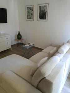 ein Wohnzimmer mit einem weißen Sofa und einem Tisch in der Unterkunft Apartman SIMON-CENTAR in Nova Gradiška