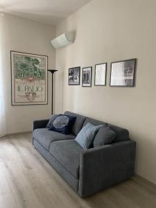 uma sala de estar com um sofá cinzento num quarto em Casa del Riccio, Palio Siena em Siena