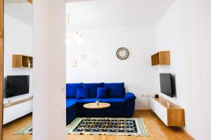 ein Wohnzimmer mit einem blauen Sofa und einem Tisch in der Unterkunft Matias sweetest home in Tirana