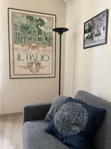 een woonkamer met een bank en een foto aan de muur bij Casa del Riccio, Palio Siena in Siena