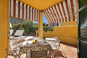 a patio with a table and chairs on a balcony at Isabel Beach and Bike in Finale Ligure