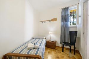 a bedroom with a bed and a chair and a window at Isabel Beach and Bike in Finale Ligure
