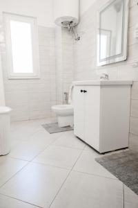 ein weißes Bad mit einem Waschbecken und einem WC in der Unterkunft Matias sweetest home in Tirana
