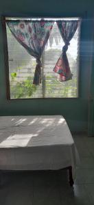 een slaapkamer met een raam en een bed ervoor bij Casa de Doña Horte in Catemaco