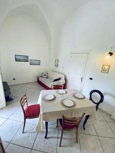 a room with a table and chairs and a couch at Victoria Apt - Historical Centre Lecce in Lecce