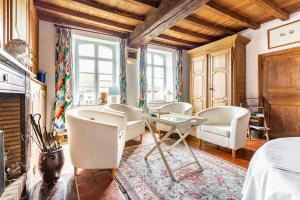 uma sala de estar com cadeiras brancas e uma lareira em Ferme De Guersignies B&B em Bas-Lieu
