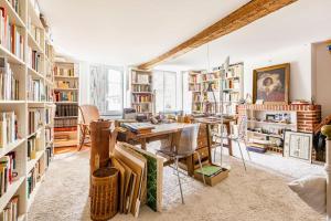 um quarto com uma secretária e uma biblioteca com livros em Ferme De Guersignies B&B em Bas-Lieu