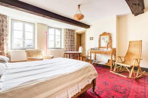 a bedroom with a large bed and a desk at Ferme De Guersignies B&B in Bas-Lieu