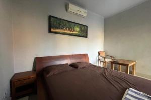 - une chambre avec un lit et une photo sur le mur dans l'établissement OYO 92909 Penginapan Sarinah Syariah, 