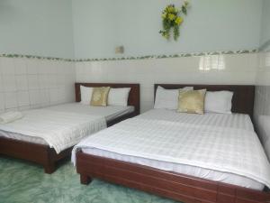 two beds sitting next to each other in a room at Ngoc Mai 1 Hotel in Can Tho