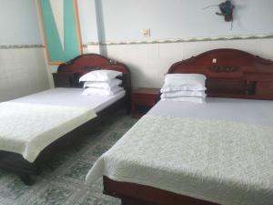 two beds sitting in a room with at Ngoc Mai 1 Hotel in Can Tho +3 photos