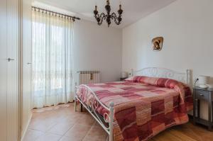 een slaapkamer met een bed en een kroonluchter bij Casa Vacanza Rocchetti with Parking&Garden! in Porcari